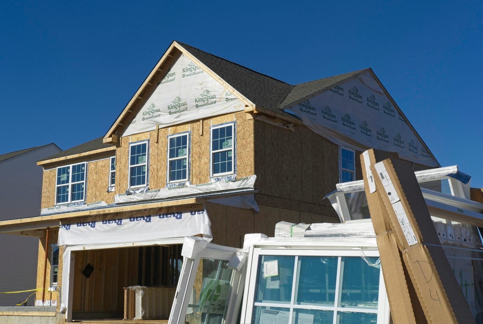 A new house under construction with wood framing and house wrap