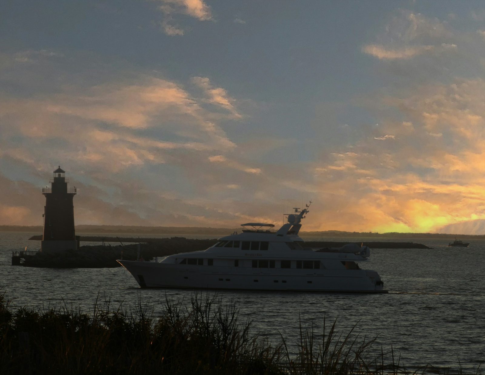 A lighthouse and a yacht on the water at dusk off Cape Henlopen